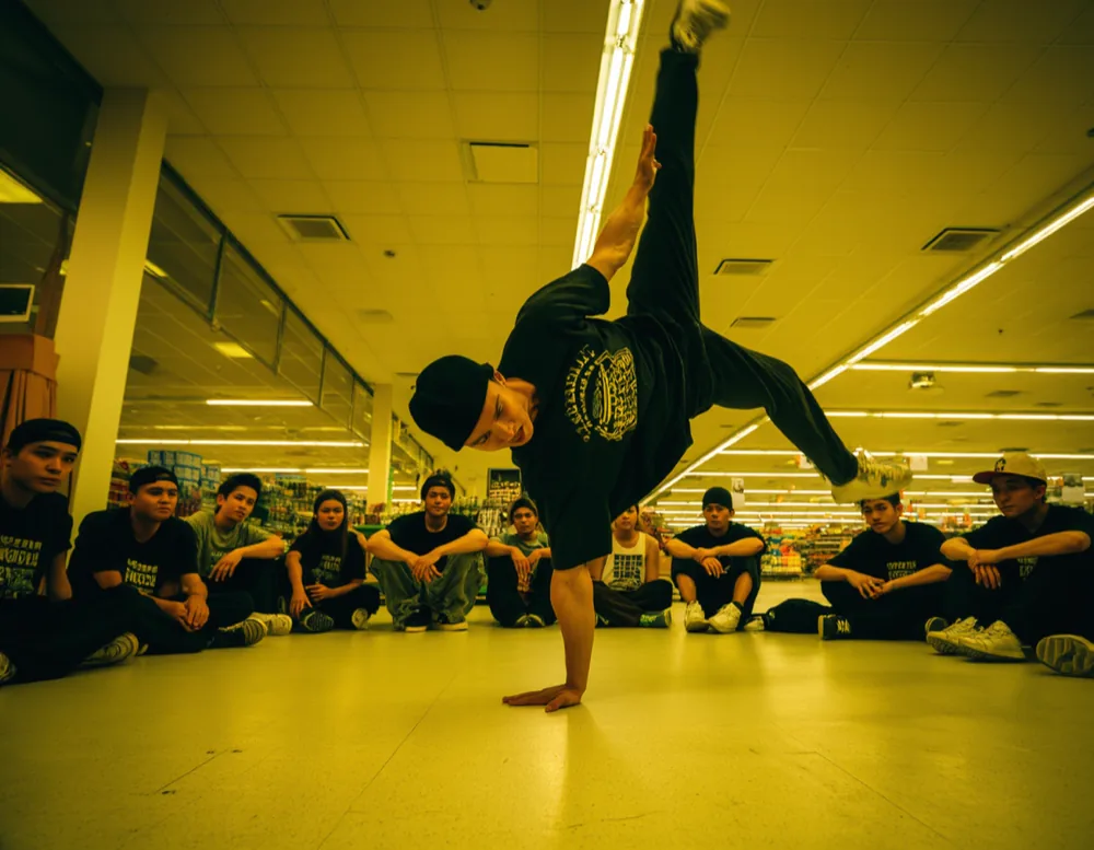 A dancer holding a one-handed freeze while the circle watches